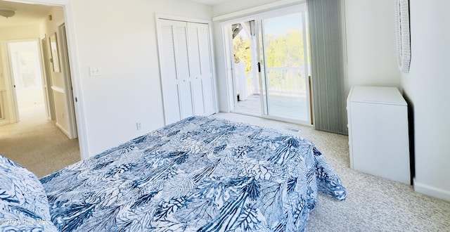 carpeted bedroom with access to outside and fridge