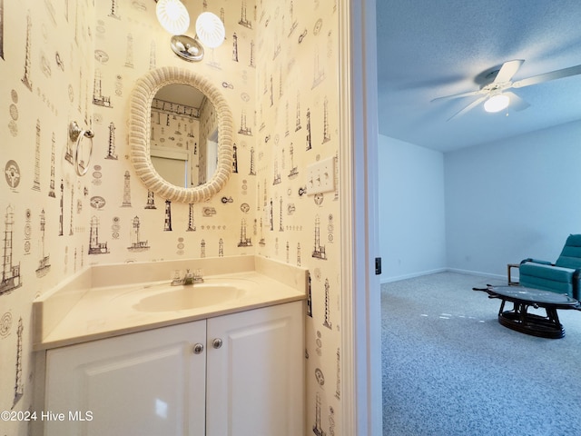 bathroom featuring ceiling fan, vanity, and a textured ceiling