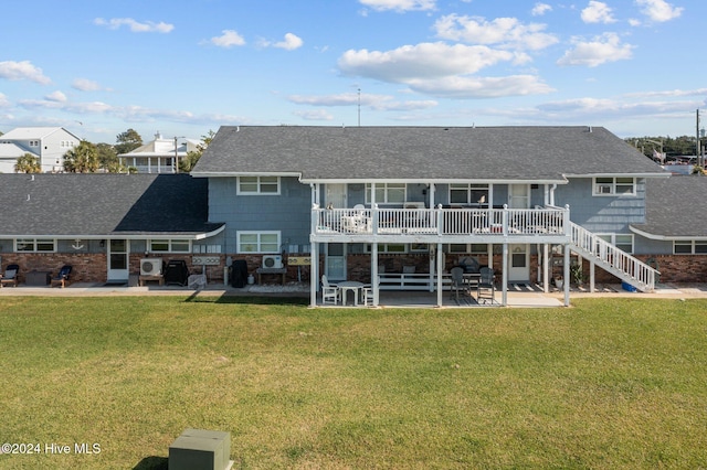 rear view of property with a wooden deck, a patio, and a yard