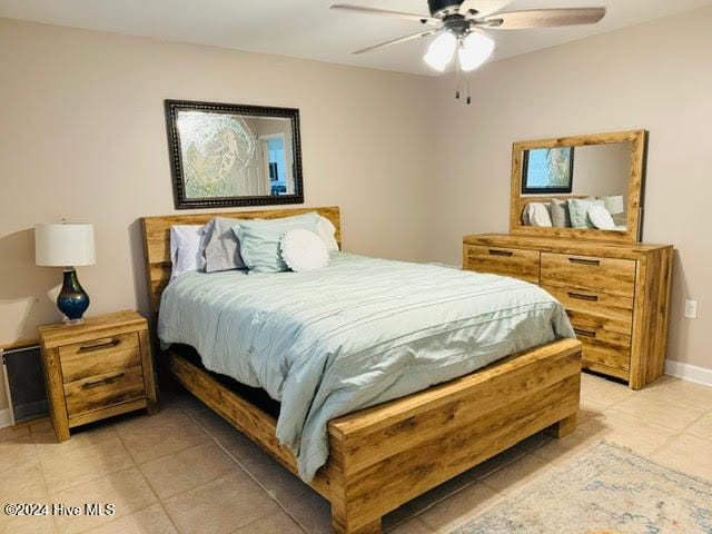 tiled bedroom featuring ceiling fan