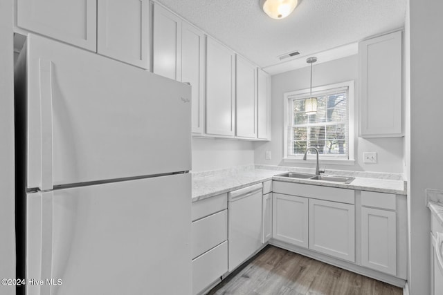 kitchen with a textured ceiling, sink, white cabinetry, light hardwood / wood-style flooring, and white appliances