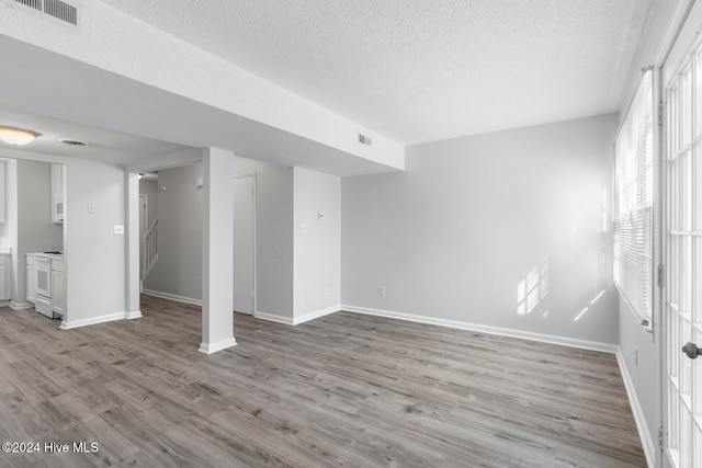 basement featuring a textured ceiling and light wood-type flooring