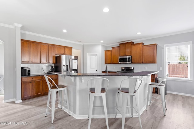 102 Hills Lorough Loop, Jacksonville, NC 28546 - kitchen featuring stainless steel appliances, brown cabinets, an island with sink, light wood-style flooring, and recessed lighting