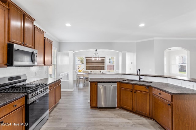 102 Hills Lorough Loop, Jacksonville, NC 28546 - kitchen featuring appliances with stainless steel finishes, a sink, ornamental molding, light wood-style flooring, and arched walkways