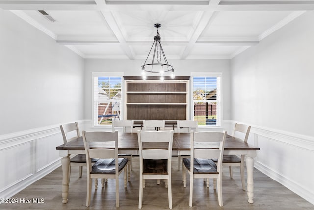 dining space featuring beam ceiling, ornamental molding, coffered ceiling, and light wood-type flooring