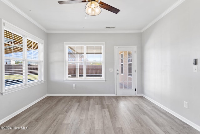 spare room featuring light wood-type flooring, plenty of natural light, crown molding, and ceiling fan