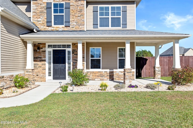 doorway to property featuring a yard and covered porch