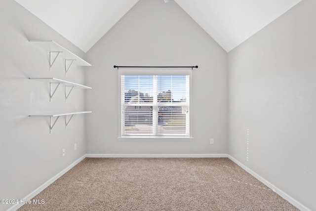 carpeted spare room featuring vaulted ceiling