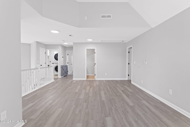 empty room featuring light hardwood / wood-style floors and stacked washer / dryer