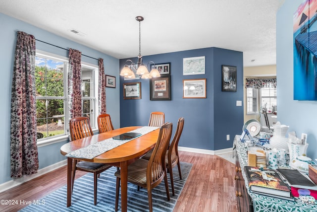 dining space featuring an inviting chandelier, hardwood / wood-style flooring, and a healthy amount of sunlight