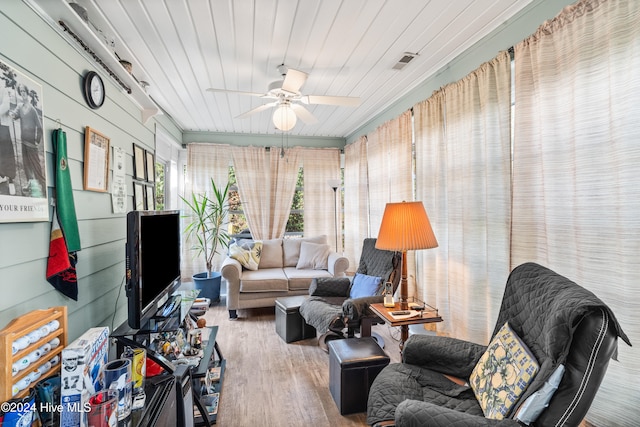 interior space with wood walls, wood ceiling, hardwood / wood-style floors, and ceiling fan