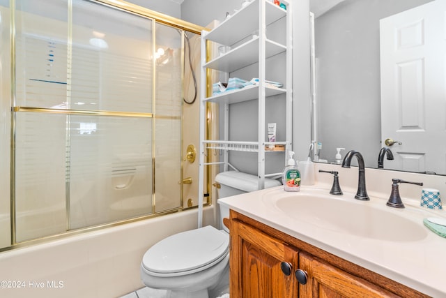 full bathroom with bath / shower combo with glass door, vanity, and toilet