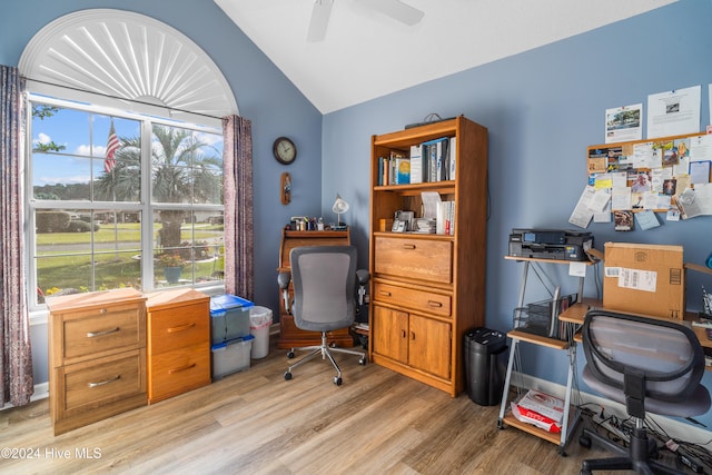 home office with light wood-type flooring, lofted ceiling, ceiling fan, and a healthy amount of sunlight