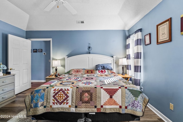 bedroom with vaulted ceiling, ceiling fan, a textured ceiling, and dark hardwood / wood-style flooring