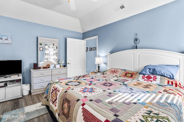 bedroom featuring dark wood-type flooring, ceiling fan, a textured ceiling, and lofted ceiling