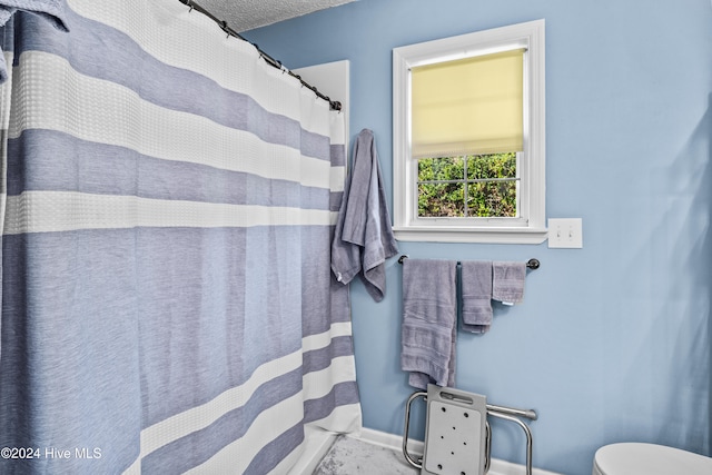 bathroom featuring a textured ceiling and a shower with shower curtain