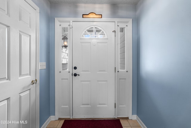 tiled entryway featuring a textured ceiling