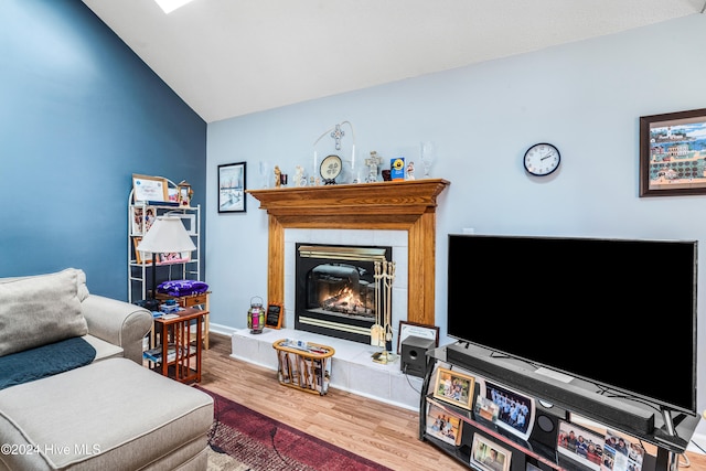 living room with a fireplace, hardwood / wood-style flooring, and lofted ceiling