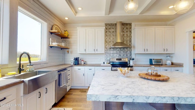 kitchen featuring stainless steel appliances, light wood-type flooring, sink, white cabinets, and wall chimney exhaust hood