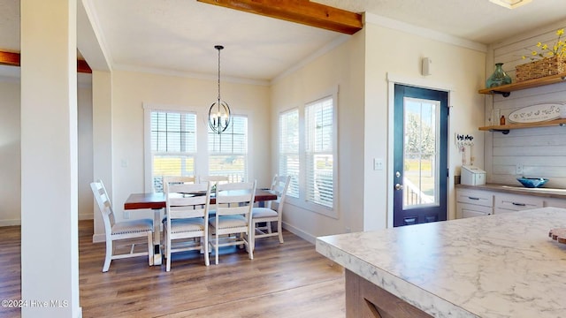 dining space featuring light hardwood / wood-style flooring, a notable chandelier, and crown molding