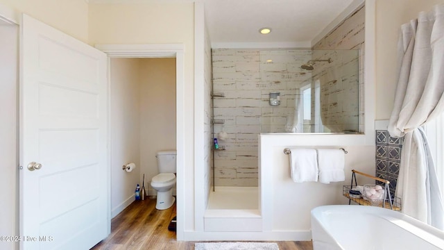 bathroom with hardwood / wood-style floors, toilet, and separate shower and tub