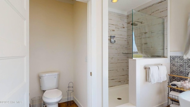 bathroom with toilet and a tile shower