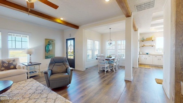 living room featuring beamed ceiling, dark hardwood / wood-style floors, and ceiling fan with notable chandelier