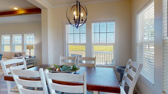 dining space featuring beamed ceiling and a notable chandelier