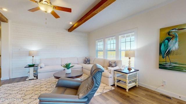 living room featuring wood-type flooring, ceiling fan, and beam ceiling