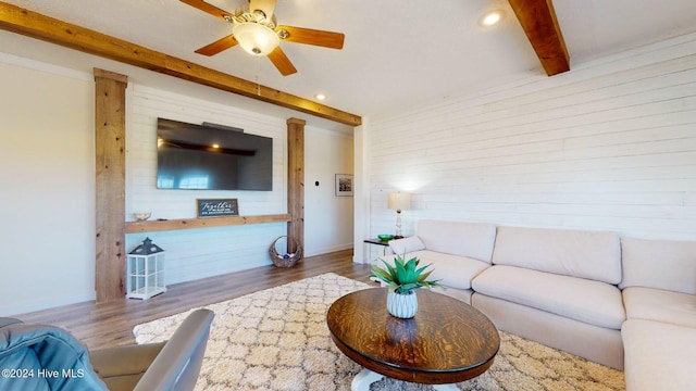 living room with beamed ceiling, hardwood / wood-style flooring, and ceiling fan