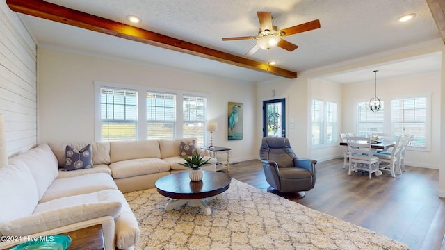 living room featuring dark hardwood / wood-style flooring, beamed ceiling, a textured ceiling, and ceiling fan with notable chandelier