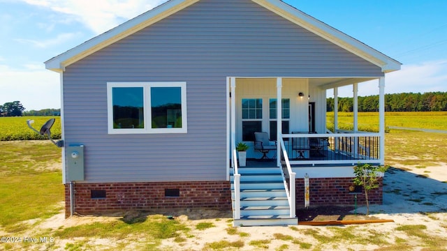 back of house with a yard and covered porch