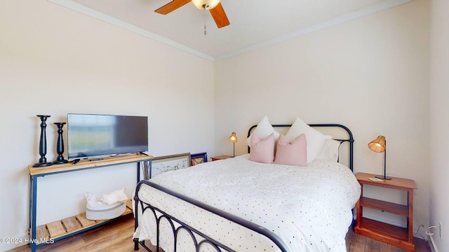 bedroom with hardwood / wood-style floors, ceiling fan, and crown molding