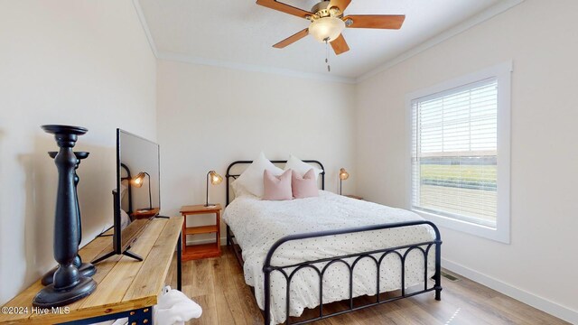 bedroom featuring wood-type flooring, ceiling fan, and crown molding