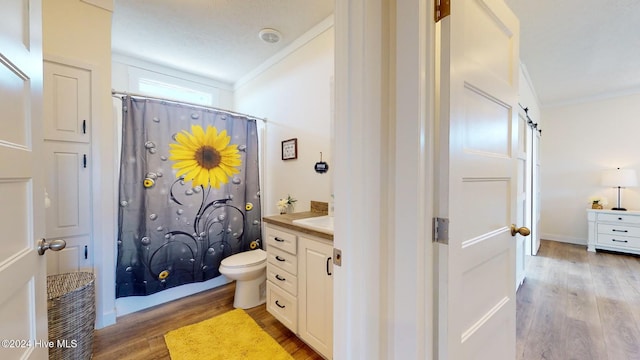 bathroom with toilet, a textured ceiling, hardwood / wood-style flooring, vanity, and crown molding