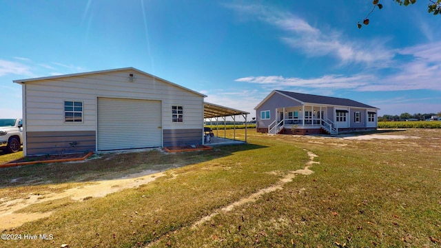 back of property featuring an outbuilding, a garage, a lawn, and a carport