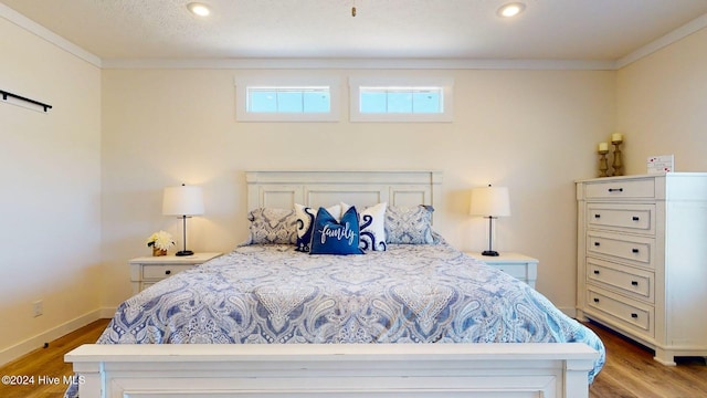 bedroom with light wood-type flooring and crown molding