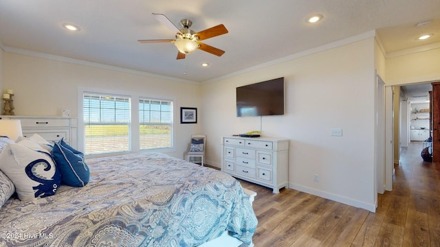 bedroom featuring hardwood / wood-style flooring, ceiling fan, and crown molding