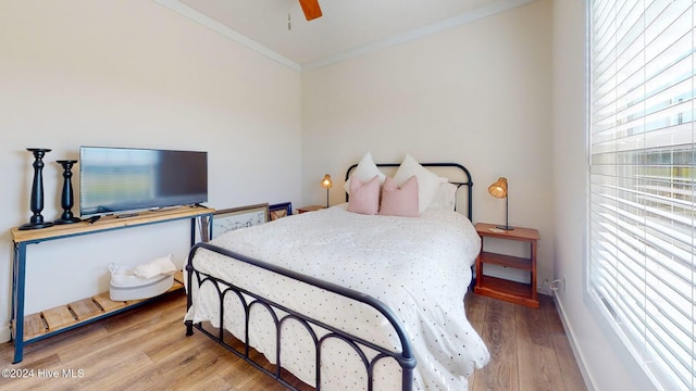 bedroom featuring hardwood / wood-style flooring, ceiling fan, and ornamental molding