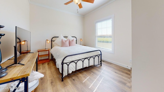 bedroom featuring ornamental molding, wood-type flooring, and ceiling fan