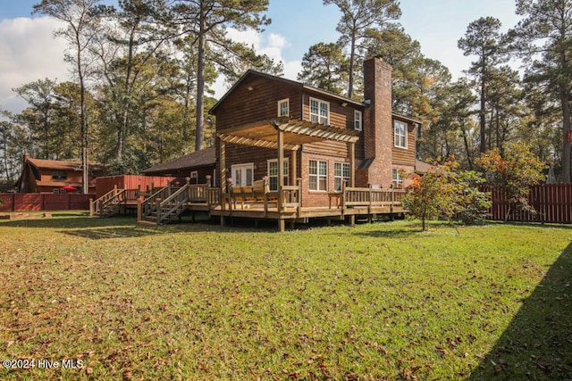 back of property with a lawn, a deck, and a pergola