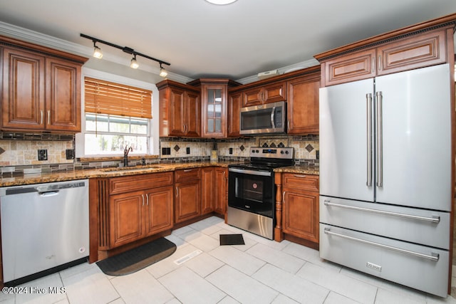 kitchen featuring backsplash, sink, light tile patterned floors, and stainless steel appliances