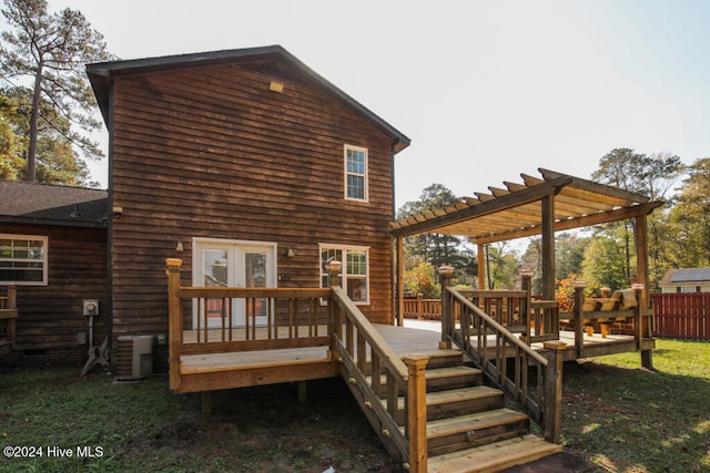 rear view of house with a pergola, a lawn, cooling unit, and a deck