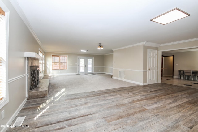 unfurnished living room with french doors, light hardwood / wood-style floors, and ornamental molding