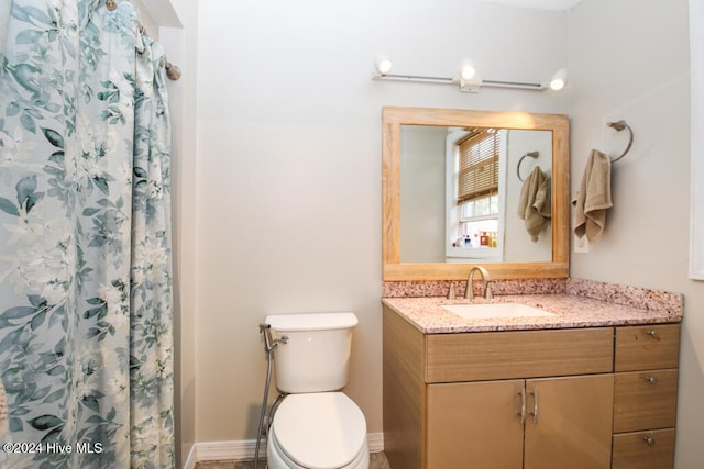 bathroom featuring walk in shower, vanity, and toilet