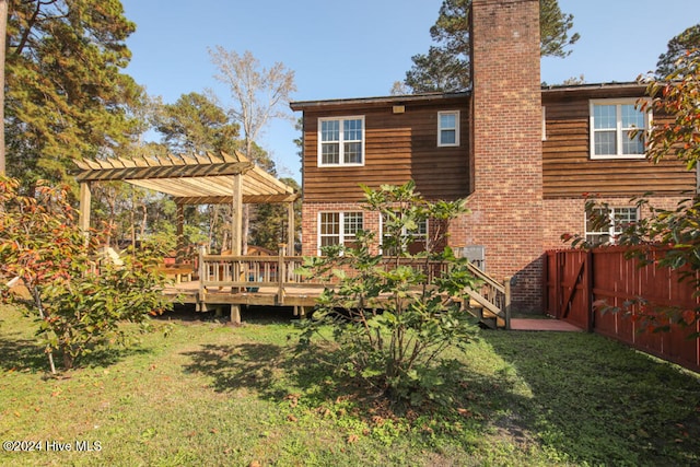 back of property with a yard and a wooden deck