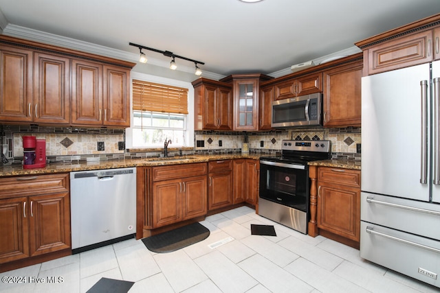 kitchen featuring tasteful backsplash, sink, dark stone counters, and appliances with stainless steel finishes