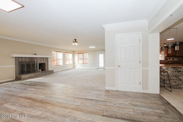 unfurnished living room featuring crown molding and light hardwood / wood-style floors