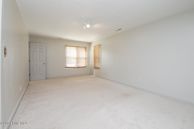 spare room featuring light colored carpet