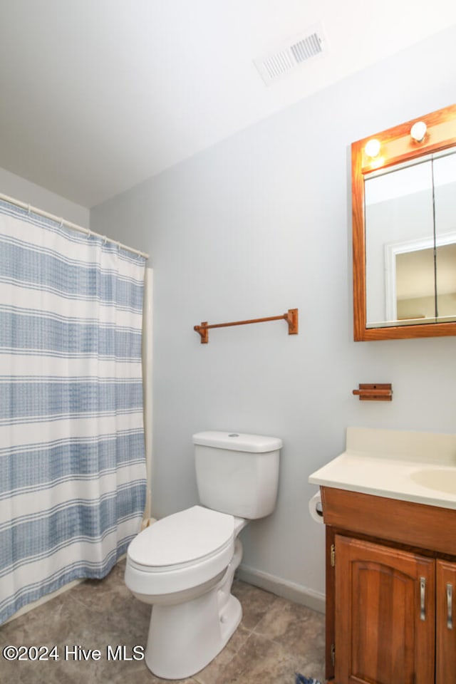 bathroom with tile patterned floors, curtained shower, vanity, and toilet